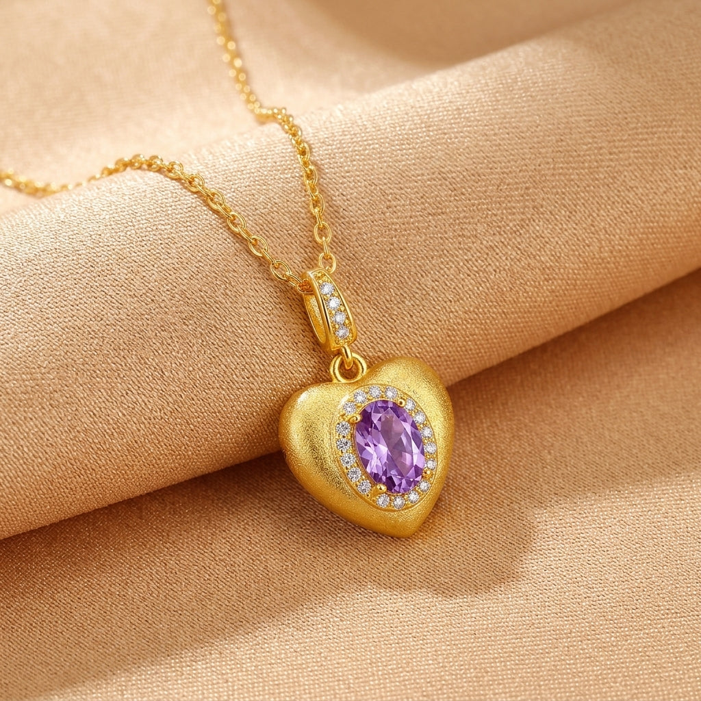 Collier en argent plaqué or avec pendentif en forme de cœur orné d'une améthyste ovale centrale entourée de petites pierres blanches, sur fond beige satiné.