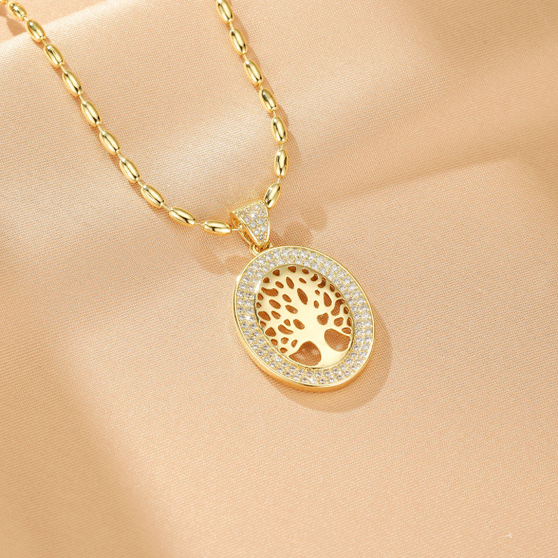 Collier plaqué or avec un pendentif ovale ajouré représentant un arbre de vie, serti de zircons cubiques brillants.