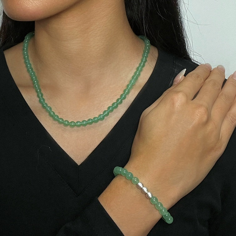 Collier et bracelet en perles d'aventurine verte sur une femme portant un haut noir