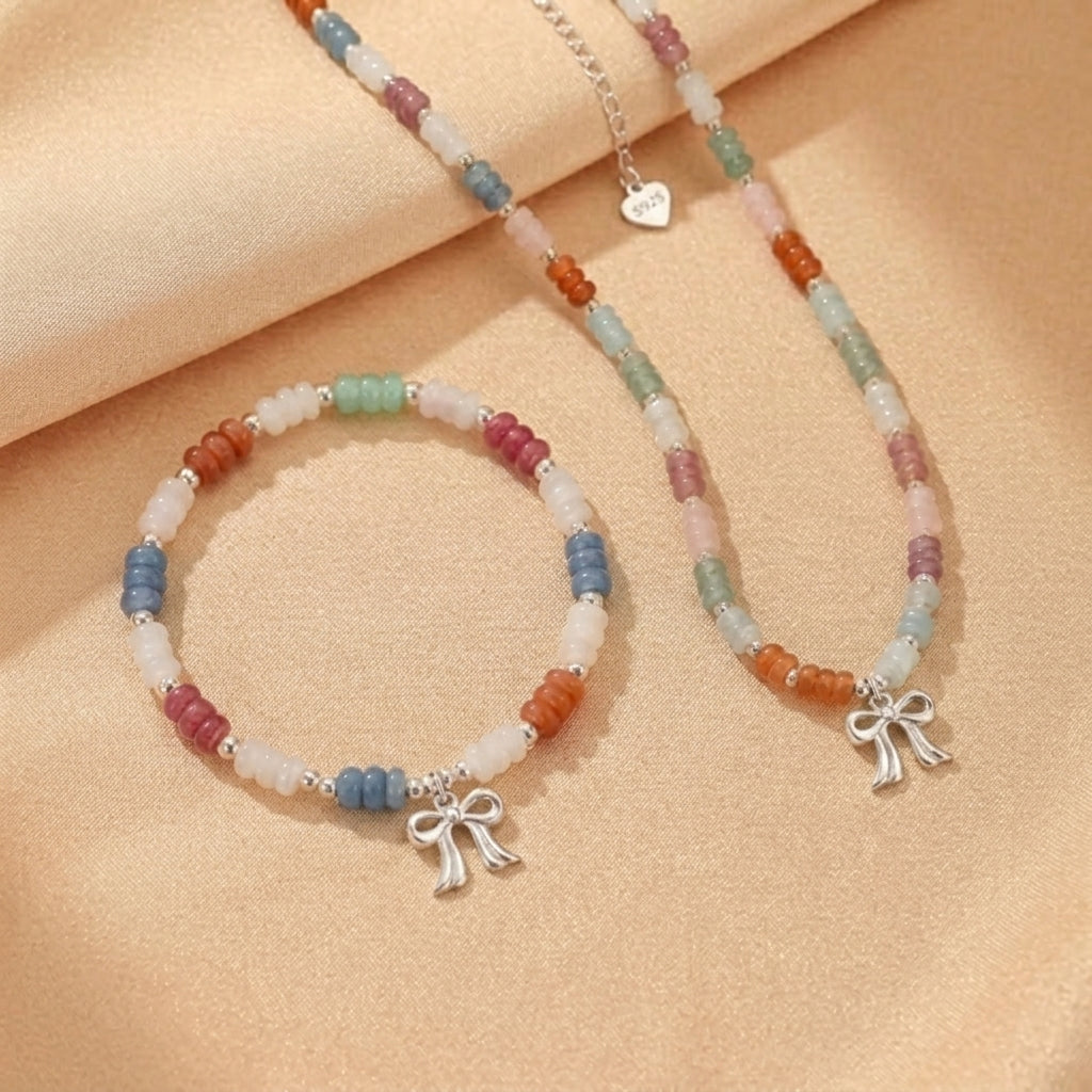 Ensemble de bijoux "Danse des Couleurs" en argent 925, comprenant un collier et un bracelet ornés de perles multicolores d'aventurine, de jade, d'aigue-marine et de quartz fraise, chaque pièce étant agrémentée d'un charmant pendentif nœud.