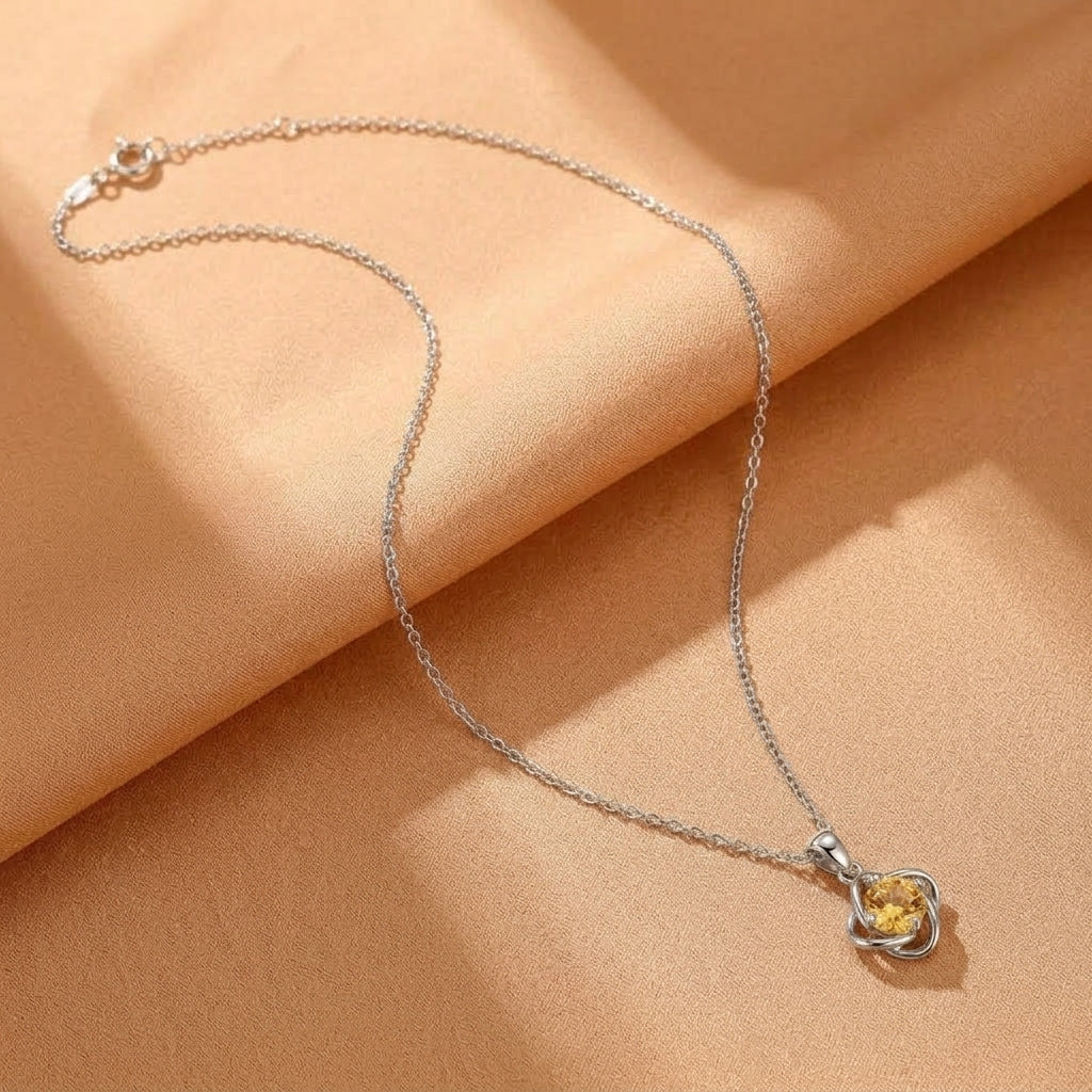 Collier en argent avec pendentif trèfle solaire orné d'une pierre de citrine jaune éclatante sur fond beige