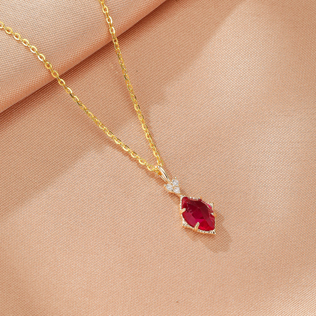 Collier en argent plaqué or avec une pierre rouge taillée en marquise et de petites pierres blanches scintillantes