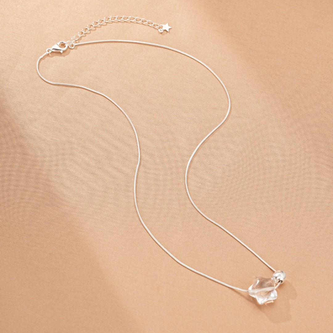 Collier fin en argent avec un pendentif en cristal de roche taillé en étoile et une petite perle ronde