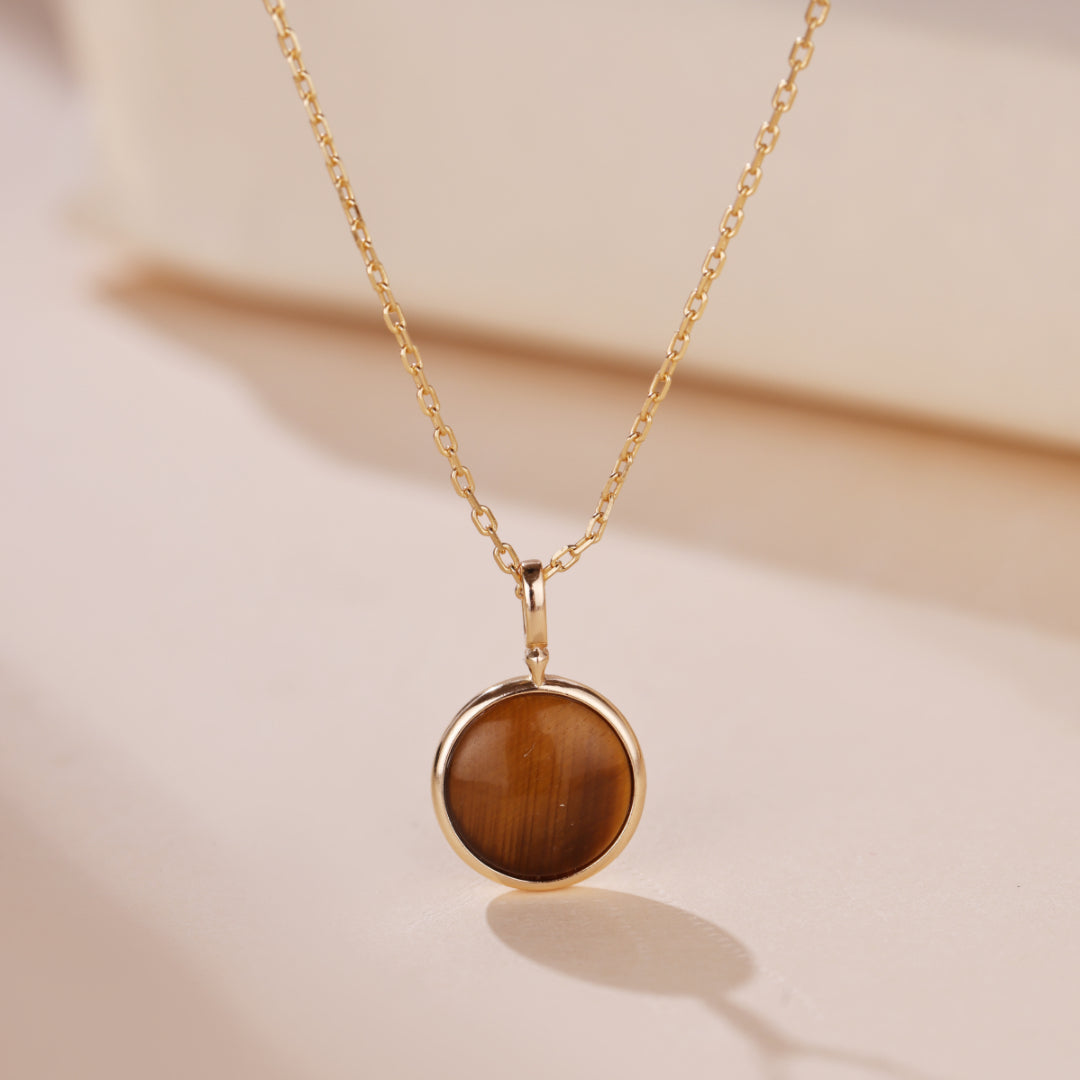 Collier "Lumière Divine" en argent plaqué or avec un pendentif rond en œil de tigre.