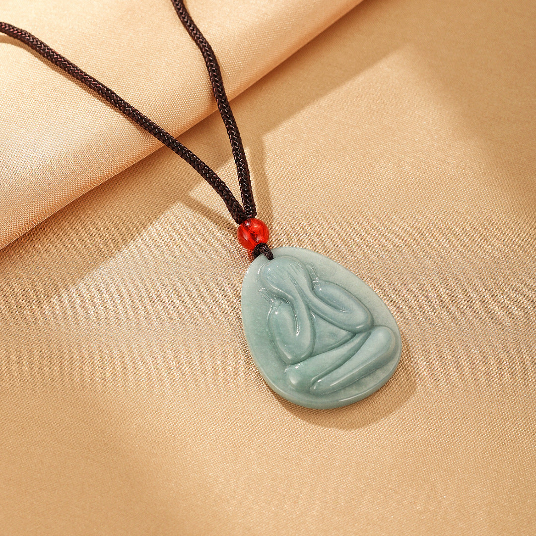 Collier pendentif en jadéite bleue Regard Intérieur représentant une silhouette méditative sur cordon noir avec perle rouge