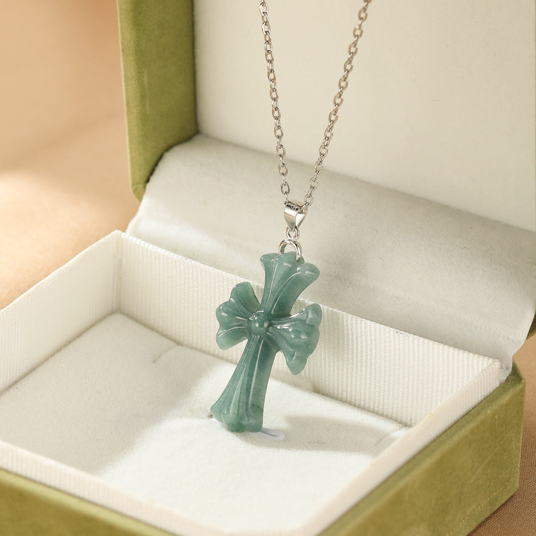 Collier Croix Sérénité en jadéite verte avec chaîne en argent, présenté dans un élégant coffret à bijoux.