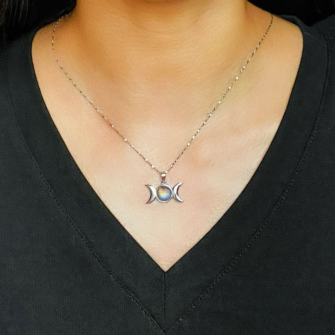 Collier en argent avec un pendentif Triple Lune orné d'une pierre de Labradorite bleue irisée, porté par une femme.