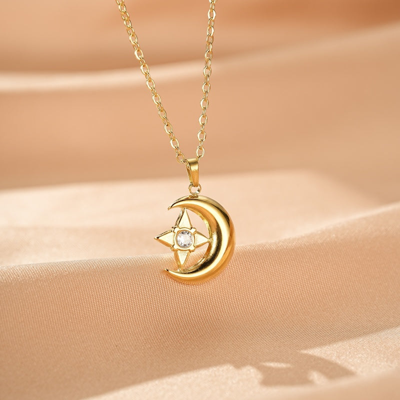 Collier en or jaune avec un pendentif en forme de croissant de lune et d'étoile orné d'un cristal scintillant.
