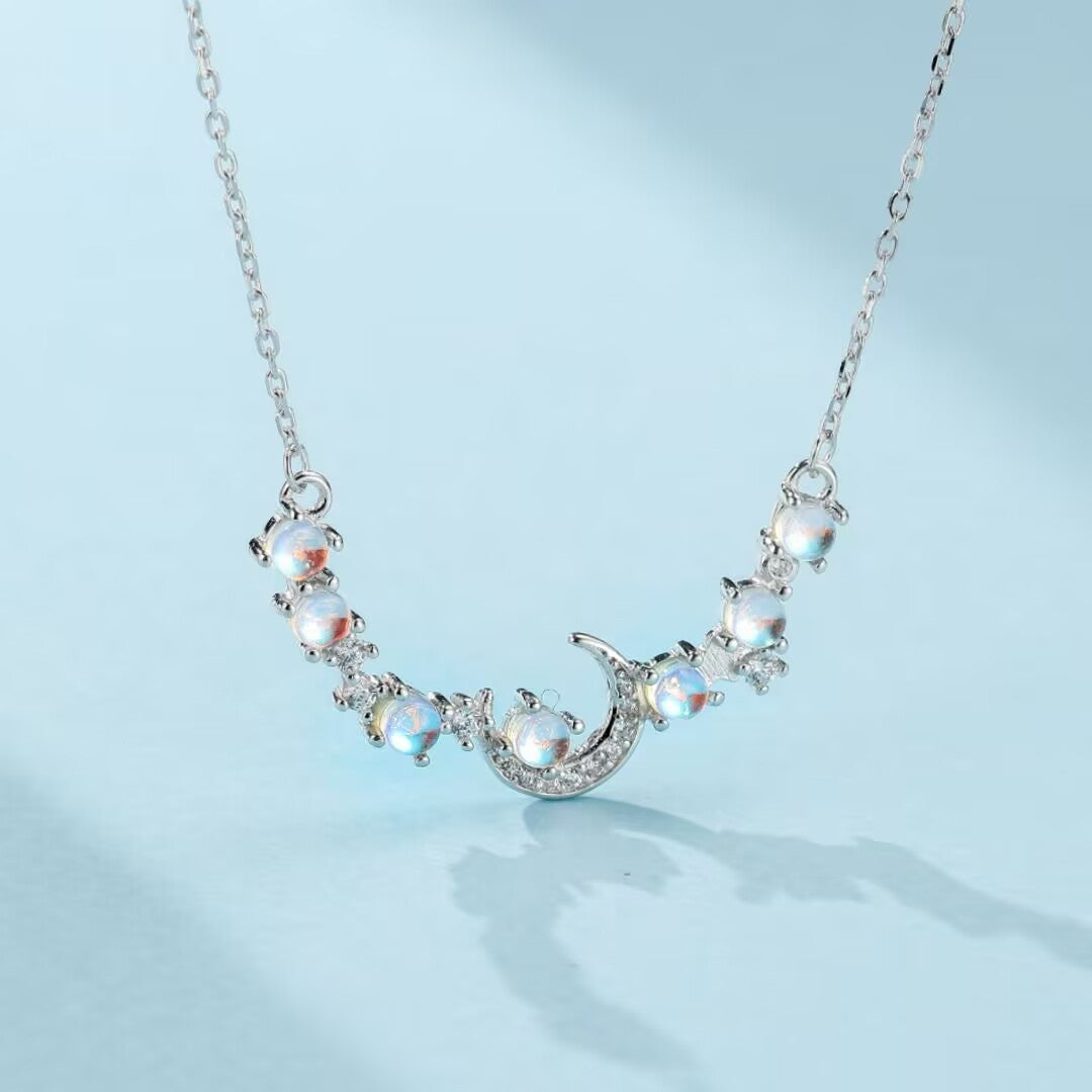 Collier "Souffle de Lune" en argent orné d'une lune stylisée et de pierres de lune rondes, capturant l'éclat céleste.