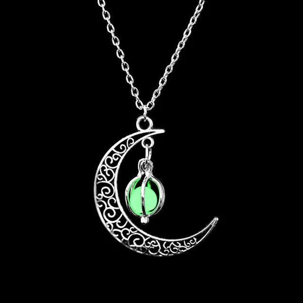 Collier argenté avec un pendentif en forme de croissant de lune ajouré, orné d'une perle fluorescente verte lumineuse.