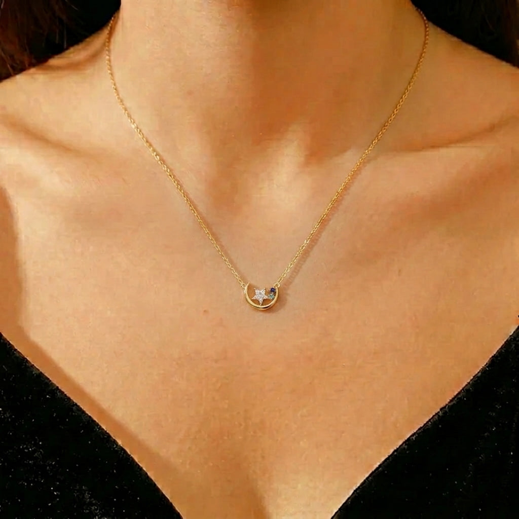 Collier en argent plaqué or 16K avec un croissant de lune orné d'une étoile blanche et de deux petites pierres bleues porté par une mannequin