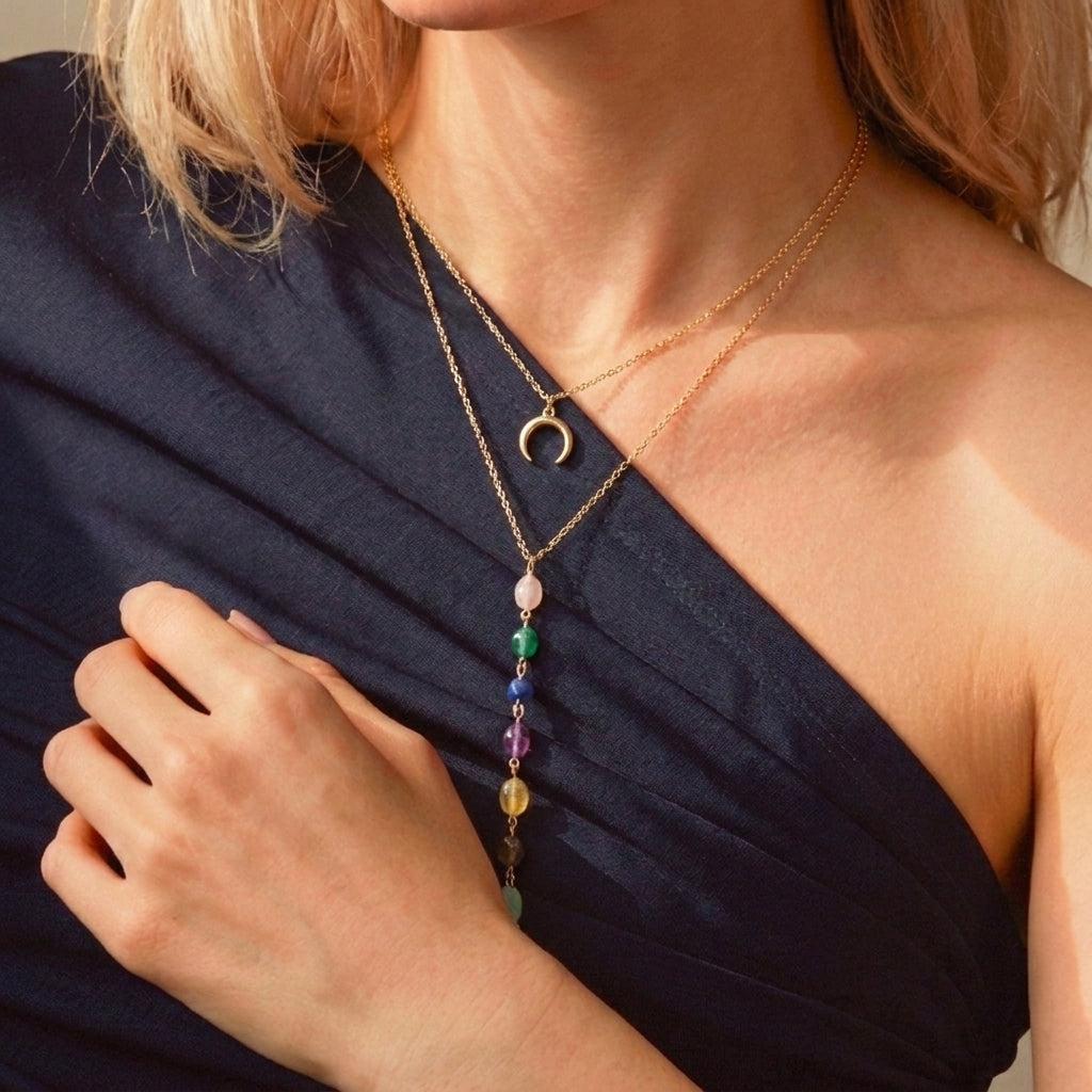 Collier double chaîne plaqué or avec un pendentif croissant de lune et une cascade de pierres naturelles multicolores.