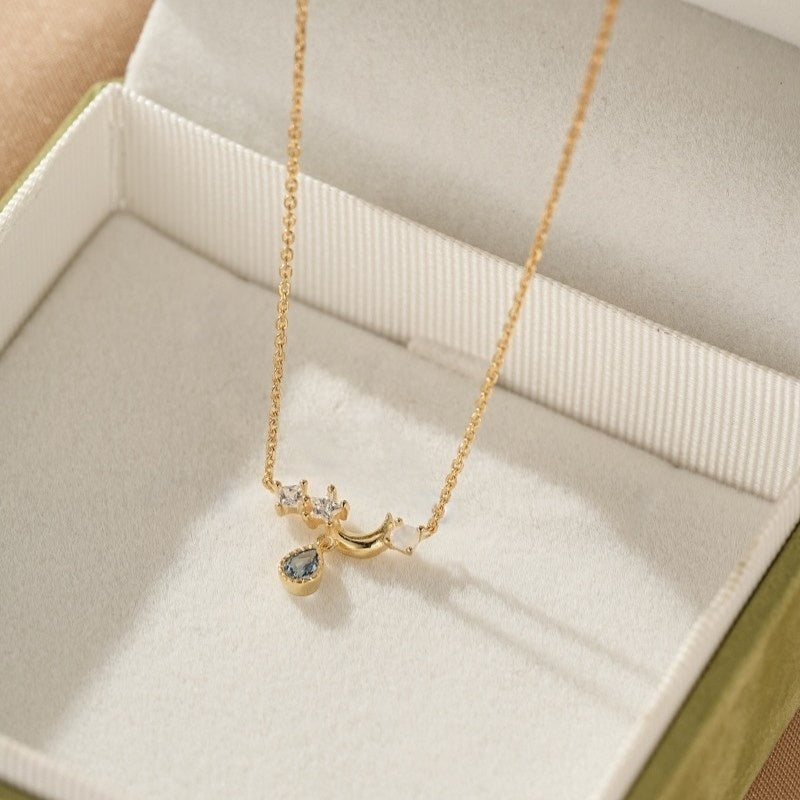 Collier Lune Topaze Astre Élégant en argent plaqué or 14k avec une pierre bleue en forme de goutte et des zircons cubiques.