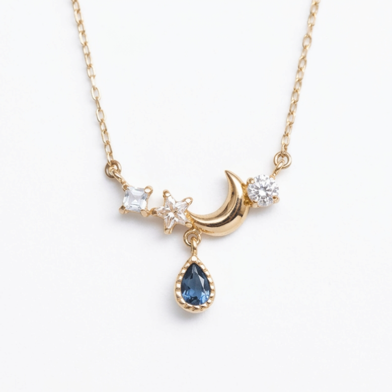 Collier élégant en argent plaqué or 14k avec pendentif en forme de croissant de lune, d'étoile et de goutte bleu saphir, orné de petites pierres scintillantes.