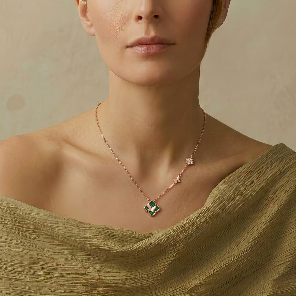 Collier en plaqué or rose avec un motif trèfle en malachite et un petit motif papillon incrusté de diamants.