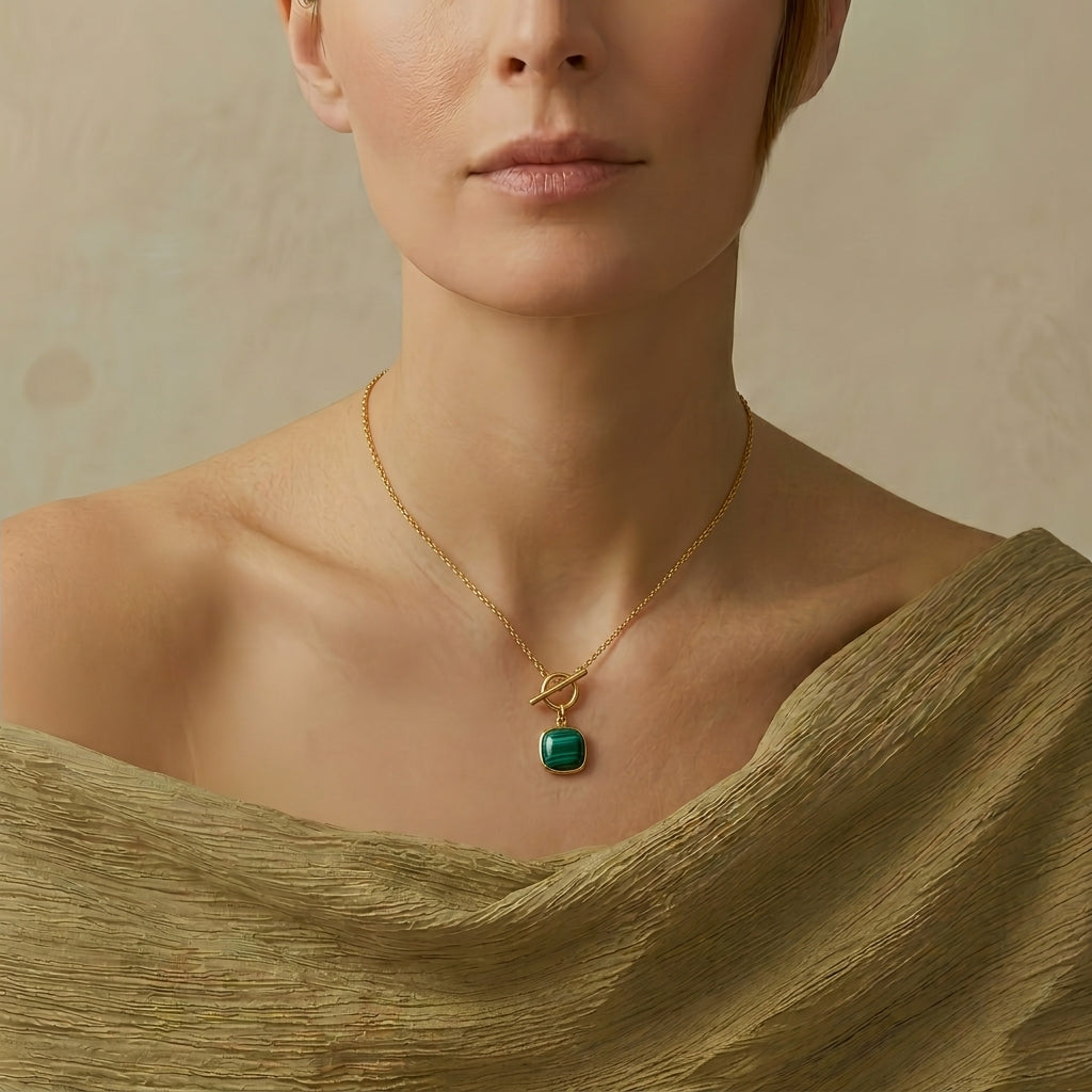 Collier Reine Sylvestre en argent plaqué or avec un pendentif carré en malachite verte porté par un modèle.