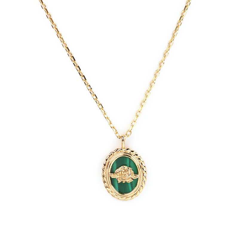 Collier en argent plaqué or 14K avec un pendentif ovale en malachite serti d'une rose dorée, sur fond blanc.