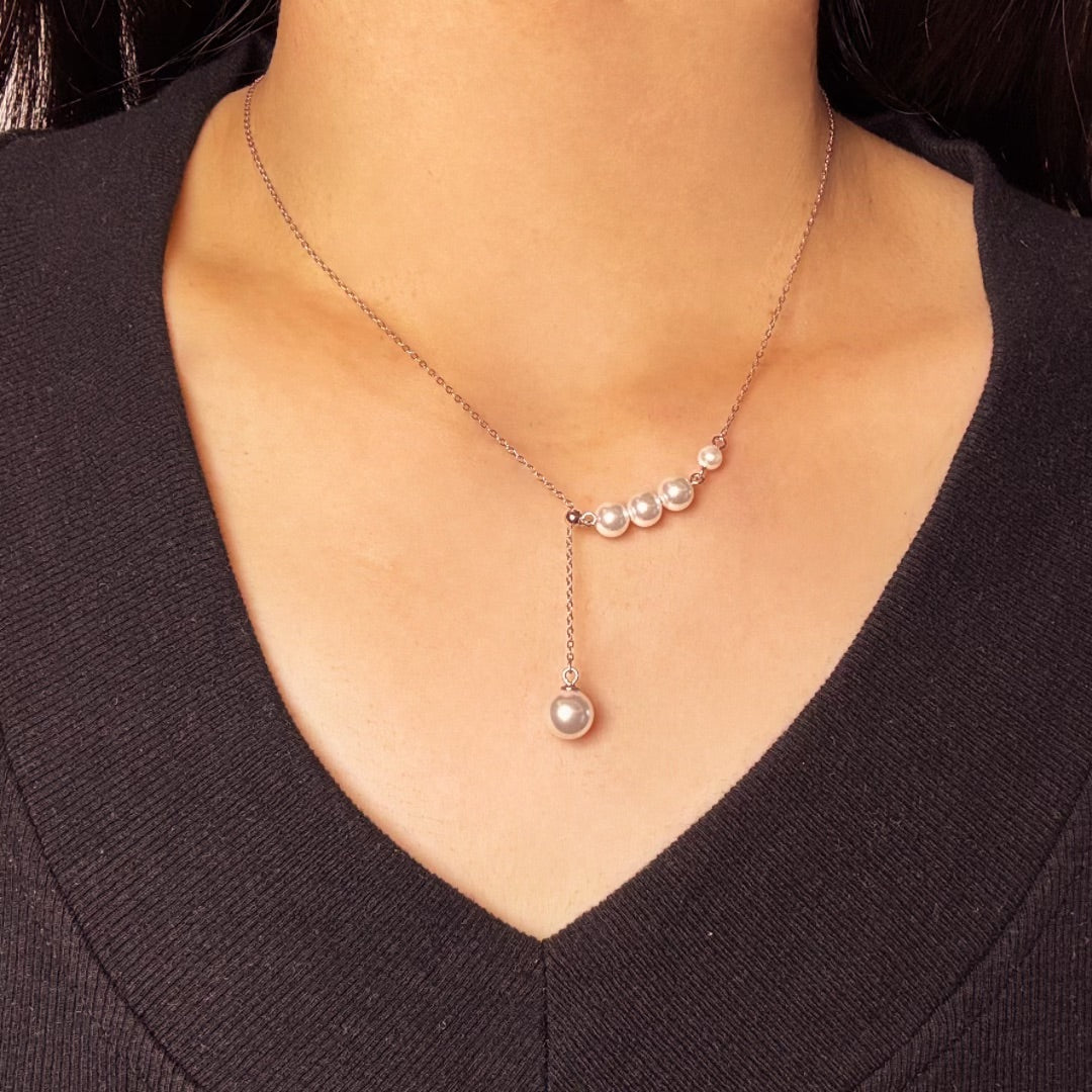 Collier moderne en argent 925 avec une chaîne délicate ornée de cinq petites perles disposées en arc et une perle plus grande suspendue en cascade.