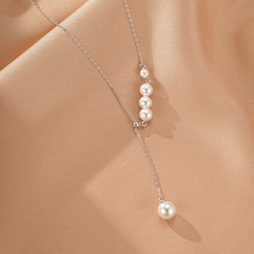 Collier en argent 925 avec une cascade de cinq perles blanches, dont une seule perle en pendant.