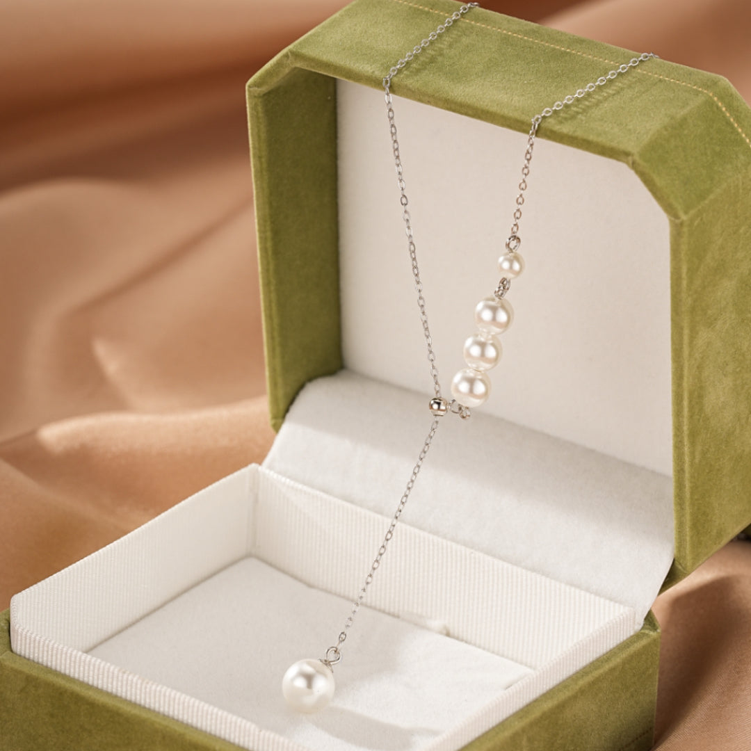 Collier élégant en argent 925 avec une cascade de perles blanches, présenté dans une boîte cadeau verte.