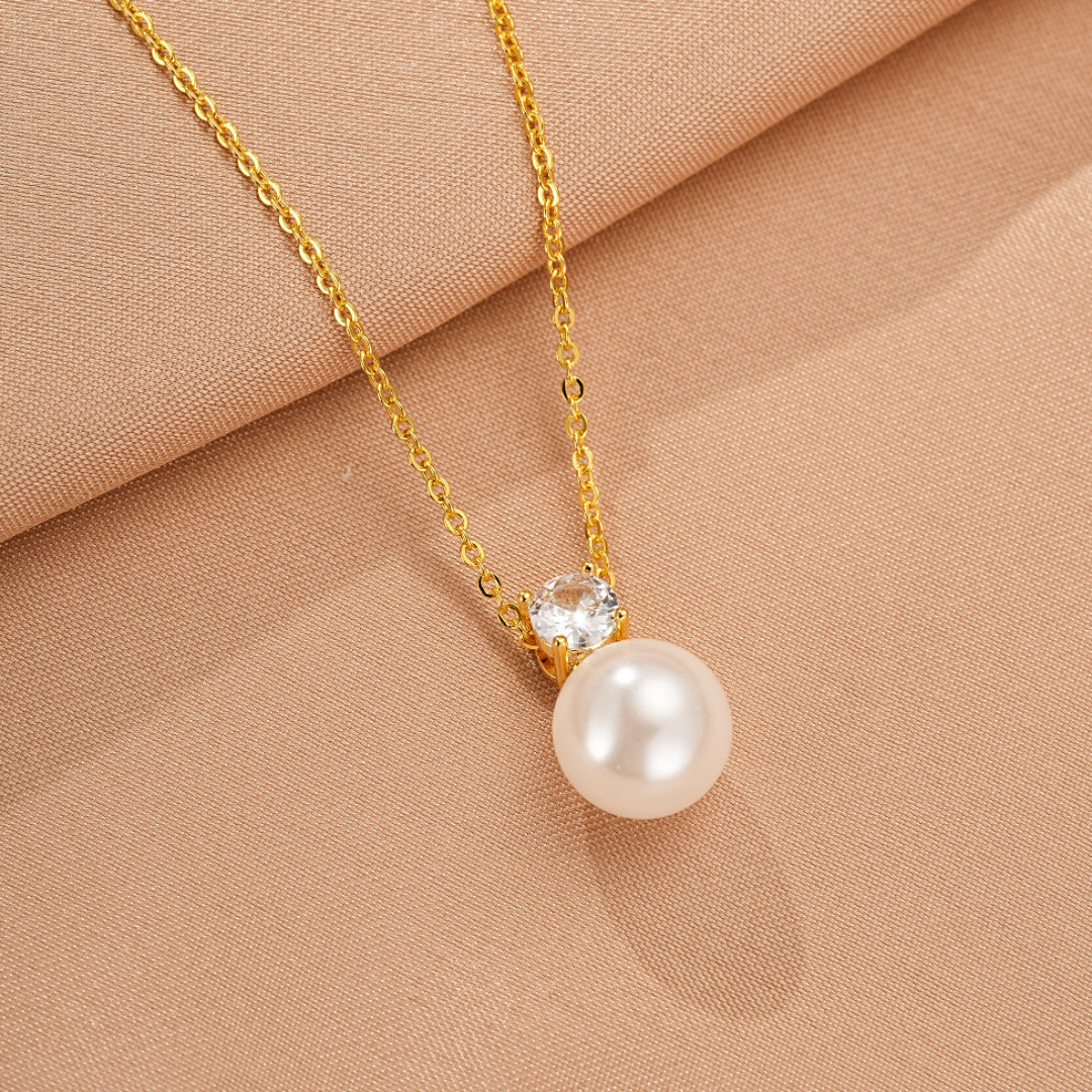 Collier en or fin avec une perle ronde blanche nacrée et un zirconium cubique scintillant