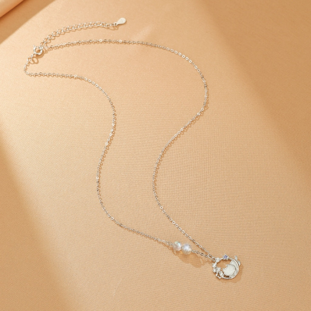 Vue rapprochée du pendentif du collier Rêve Lunaire, mettant en évidence le chaton endormi sur la lune.