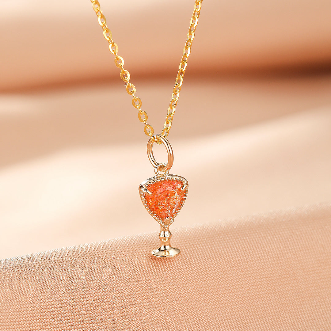 Collier avec pendentif en forme de calice orné d'une pierre de soleil scintillante, monté sur une chaîne en argent plaqué or.