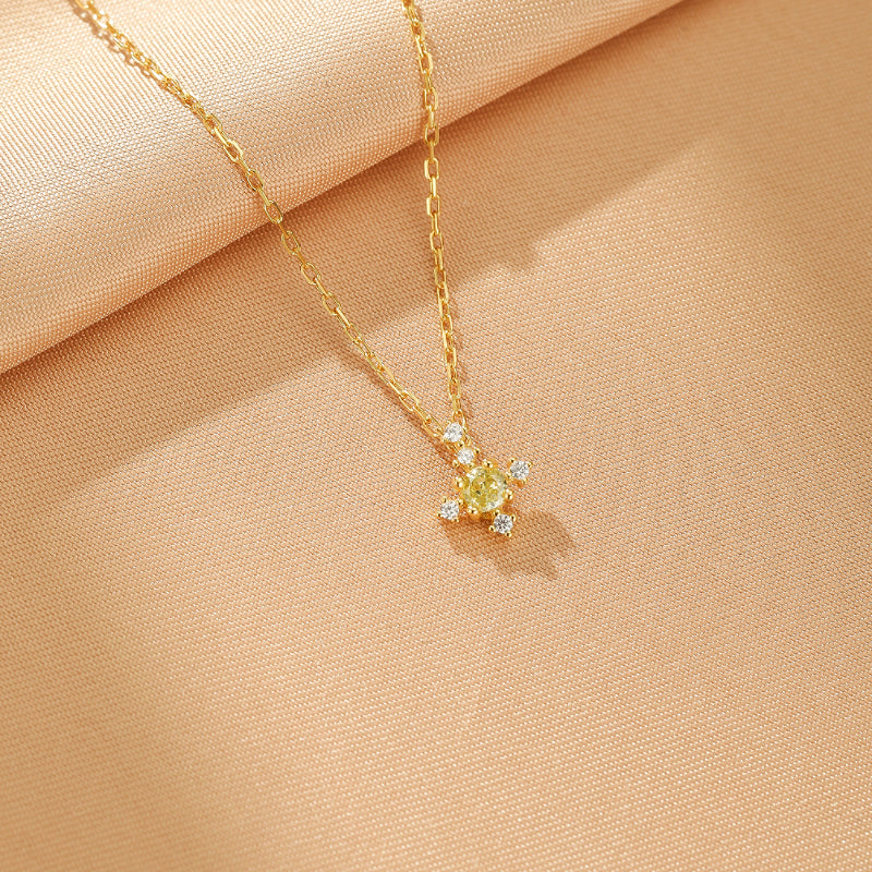 Collier Azur Infini en argent plaqué or, orné d'une pierre de naissance jaune centrale entourée de petites pierres blanches scintillantes, le tout sur une chaîne délicate.