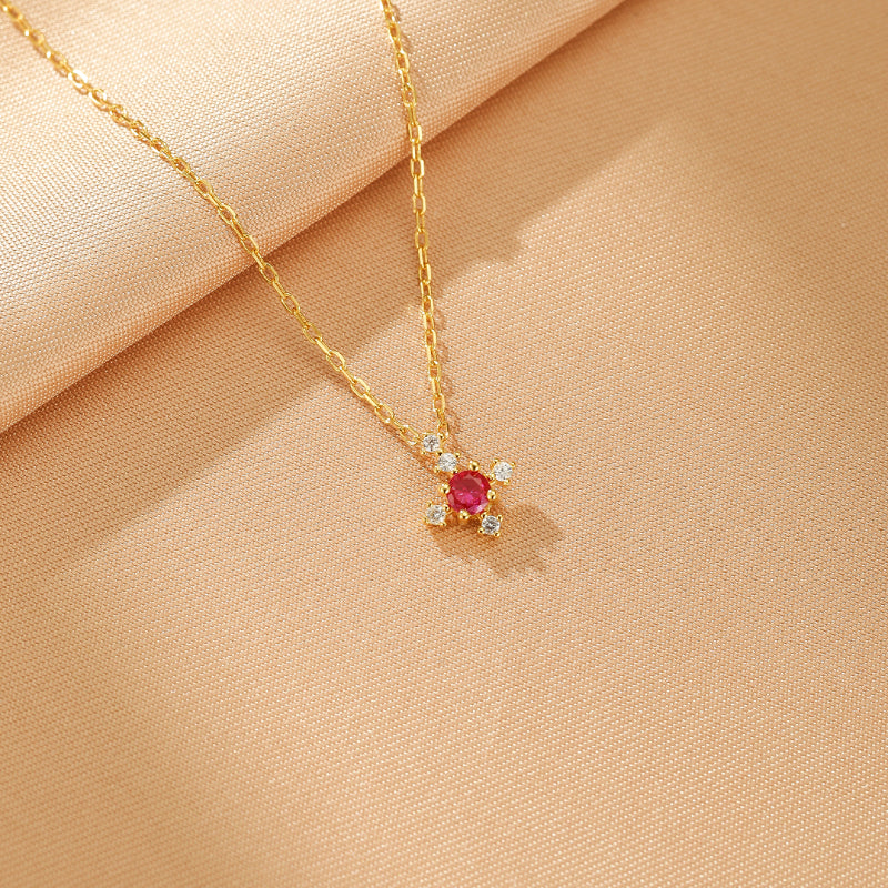 Collier Azur Infini en argent plaqué or avec une pierre de naissance rouge et de petites pierres de zircon cubique blanches serties en forme de croix.
