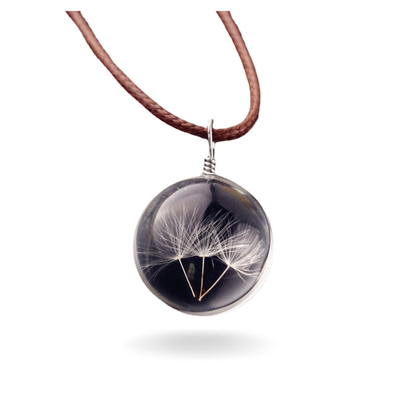 Collier pendentif rond en verre avec des graines de pissenlit suspendues à l'intérieur, monté sur un fil de cuir brun.