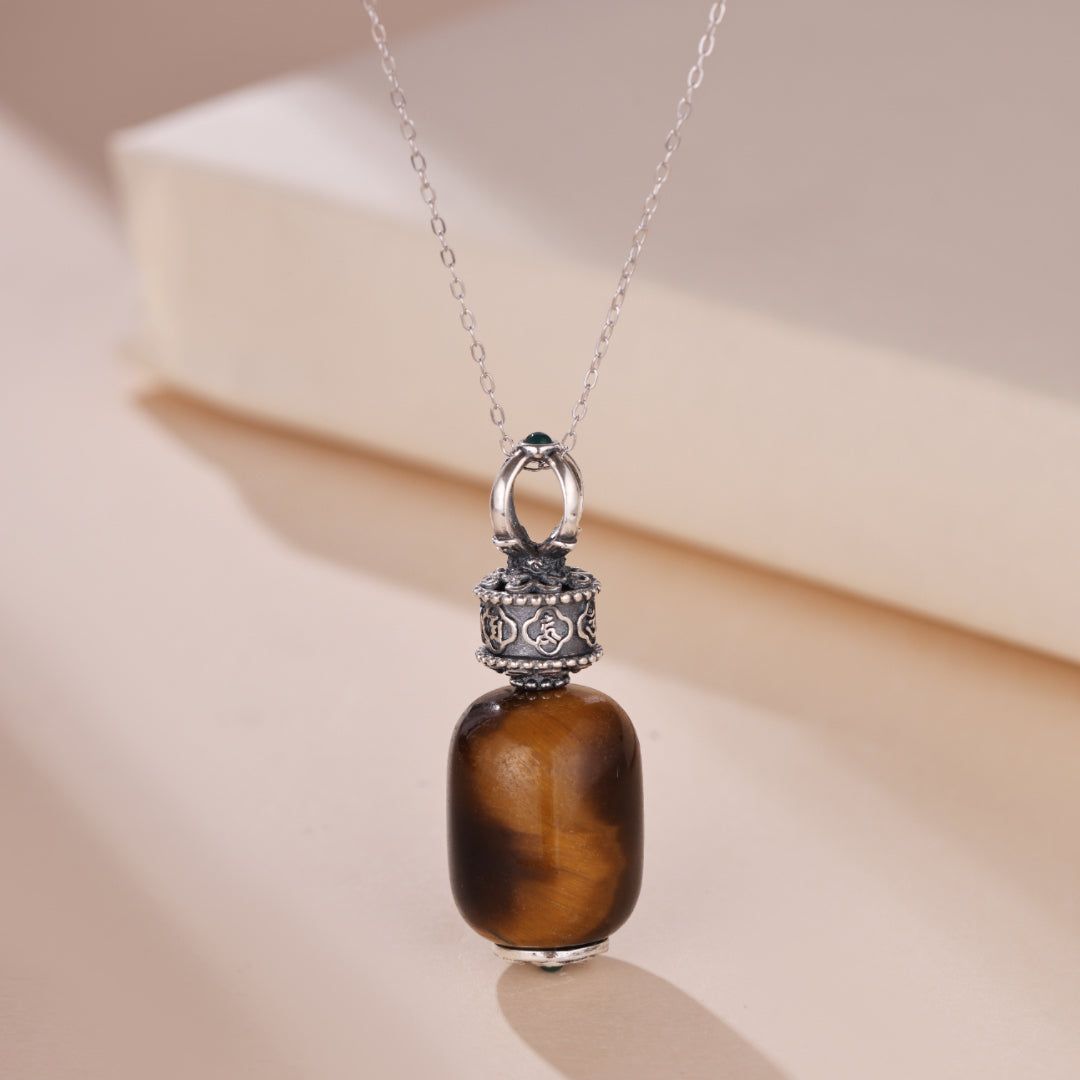 Collier en argent orné d'une pierre d'œil de tigre ovale et d'un pendentif cylindrique gravé de six mantras.
