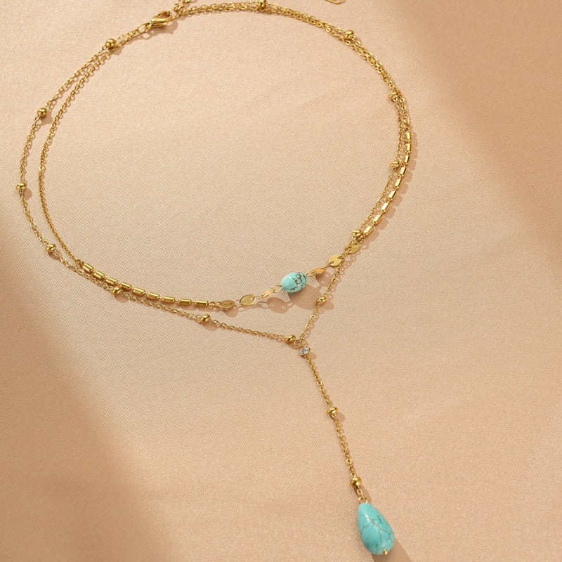 Collier double rang plaqué or avec pierres naturelles turquoise et petites pampilles en cristal.