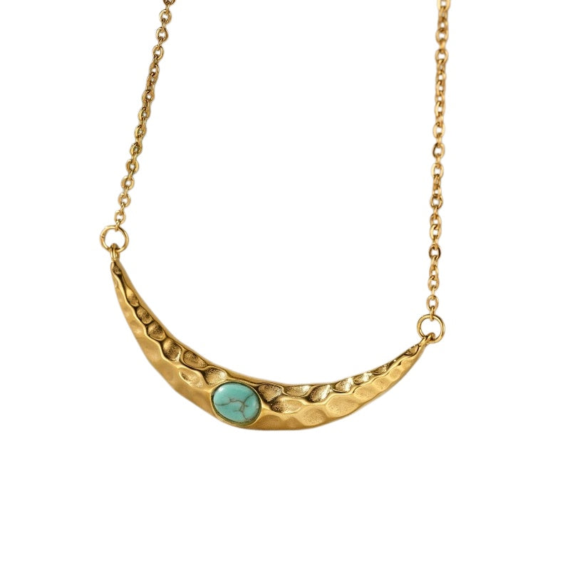 Collier plaqué or avec une pierre turquoise et un design martelé en forme de croissant de lune.