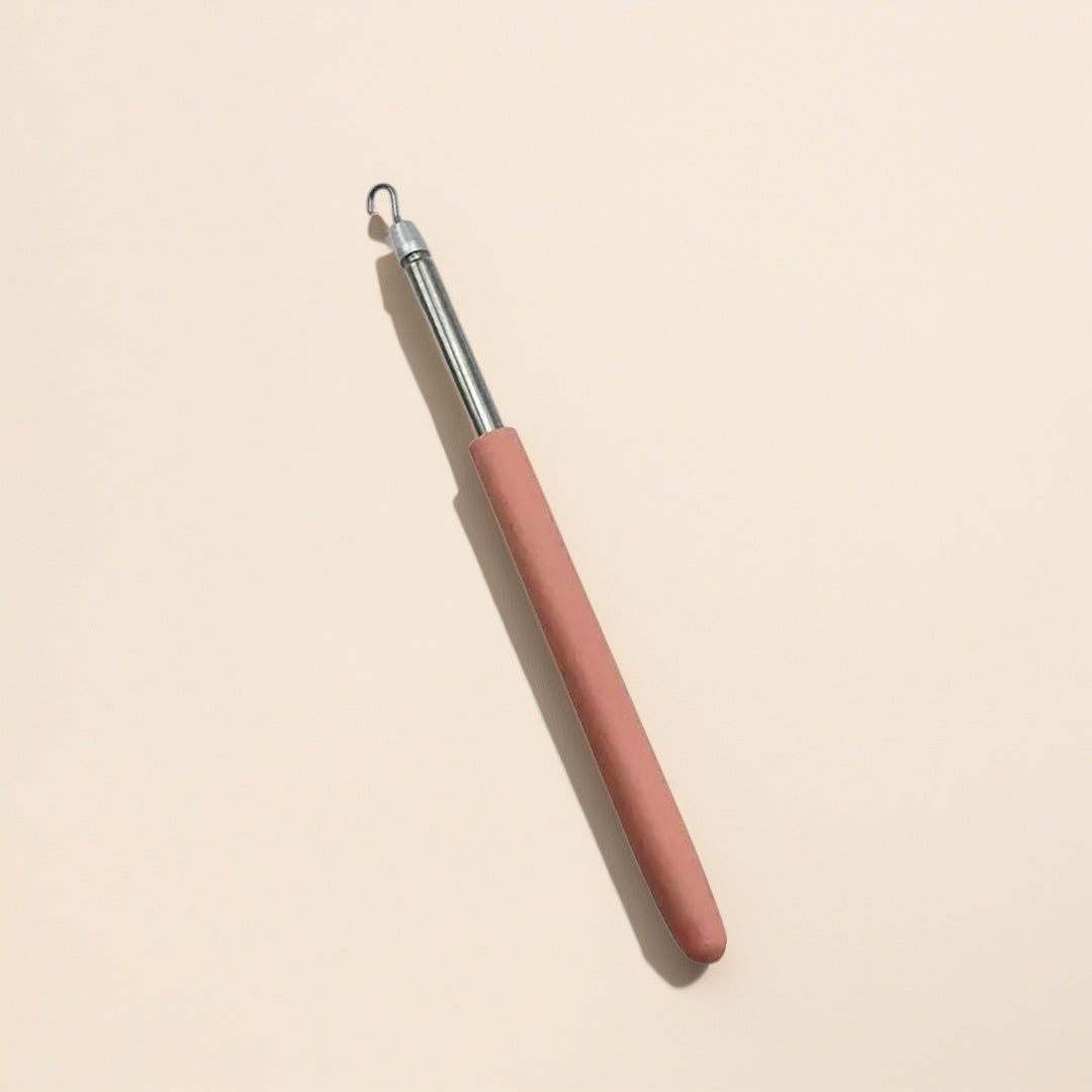 Crochet auxiliaire creux avec manche ergonomique rose pour aider à l'enfilage de bracelets