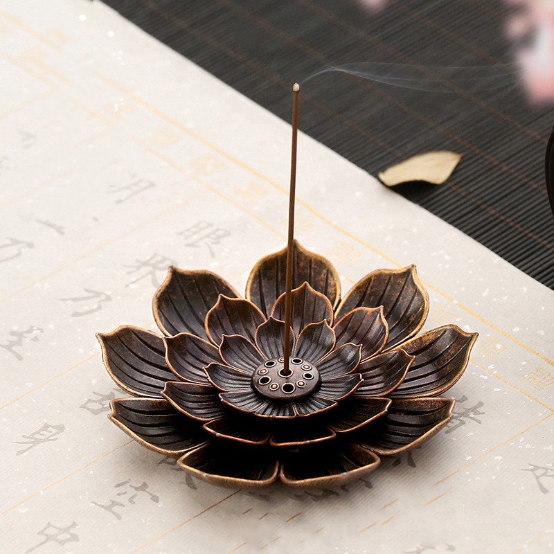 Encensoir en forme de fleur de lotus en métal avec un bâton d'encens allumé dégageant de la fumée