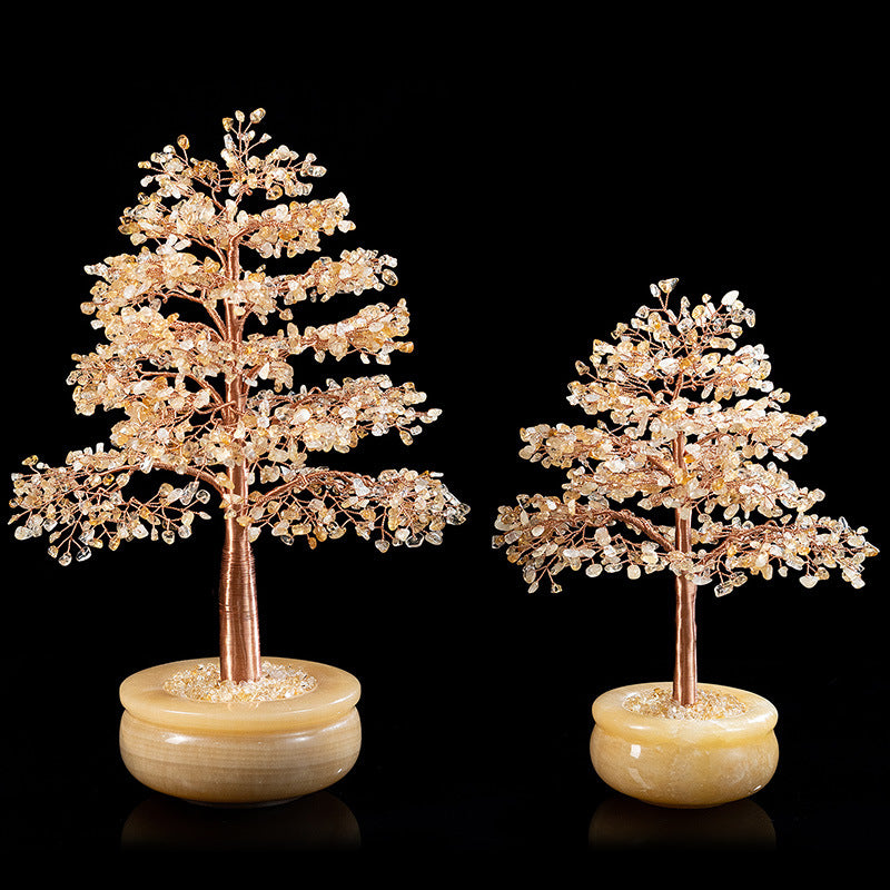 Deux arbres de vie décoratifs en pierres naturelles, l'un plus grand que l'autre, sur des socles arrondis en onyx jaune, sur fond noir.
