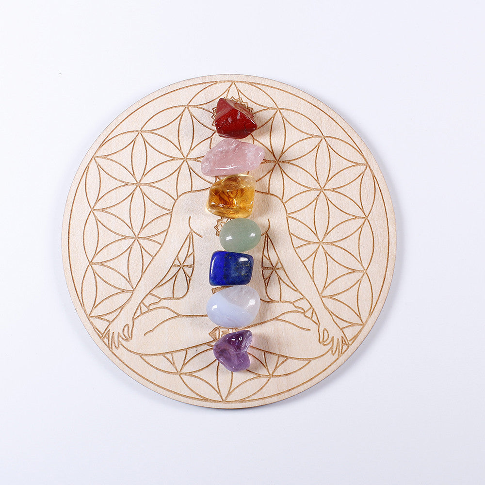 Plateau en bois gravé de la fleur de vie et d'une silhouette méditative, orné de 7 pierres naturelles polies alignées sur la colonne vertébrale : améthyste, agate bleue, lapis-lazuli, aventurine verte, citrine, quartz rose et cornaline.