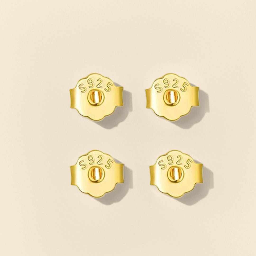 Quatre poussoirs de boucles d’oreilles en argent 925 plaqués or, vus de dos, avec inscription "S925".