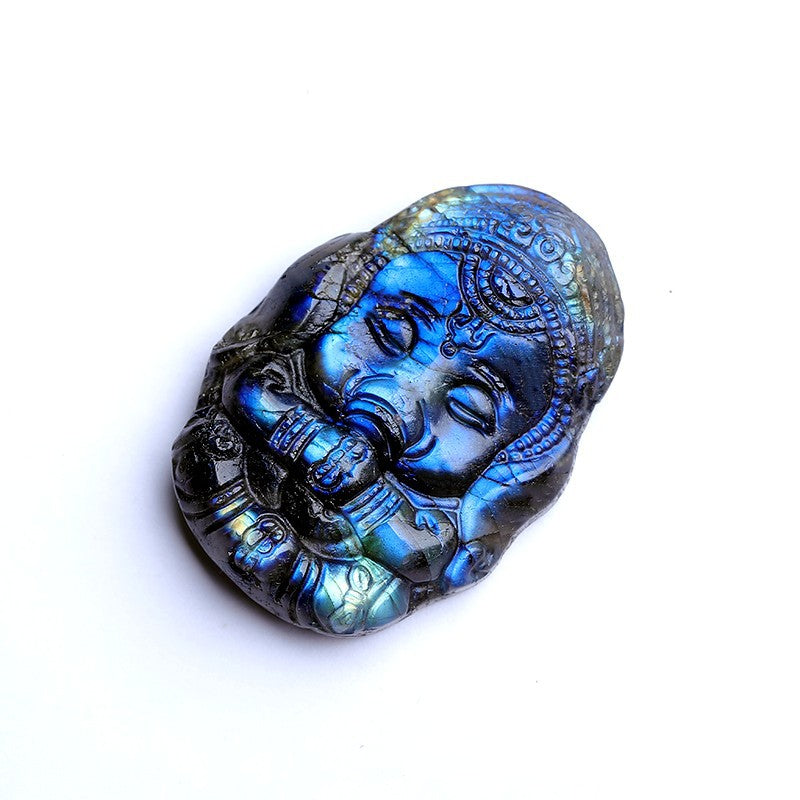 Sculpture détaillée d'un éléphant Ganesha en pierre de labradorite bleue iridescente, vue de prÚs sur fond blanc.