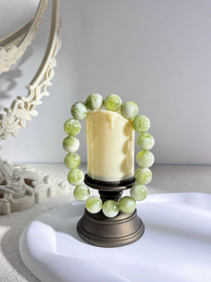 Bracelet en perle de jadéite sur une bougie sous un rayon de soleil