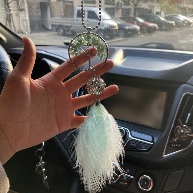 Attrape rêve Arbre de Vie "Bonheur" en pierres naturelles vertes avec une boule ajourée et des plumes douces, suspendu dans une voiture.