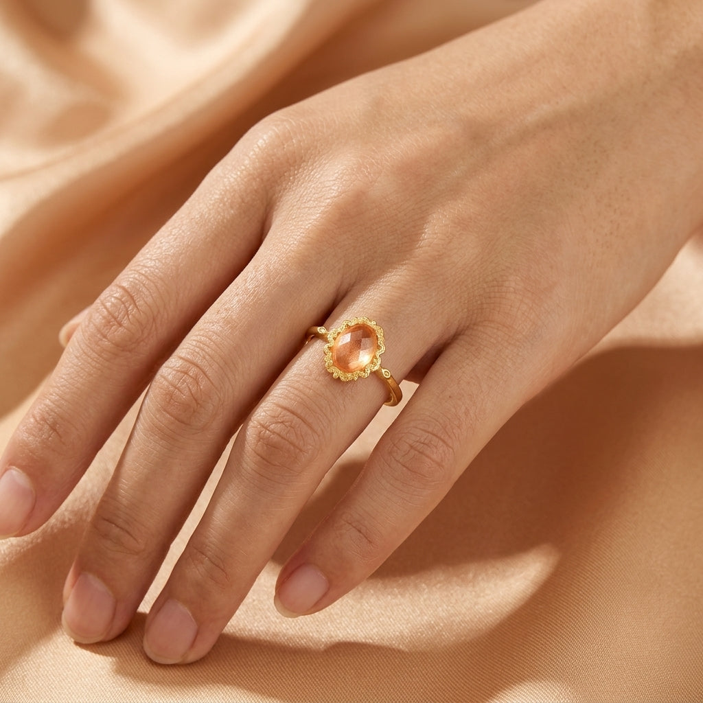 Bague fine en argent plaqué or ornée d'une pierre citrine ovale facettée portée au doigt, style élégant et lumineux.