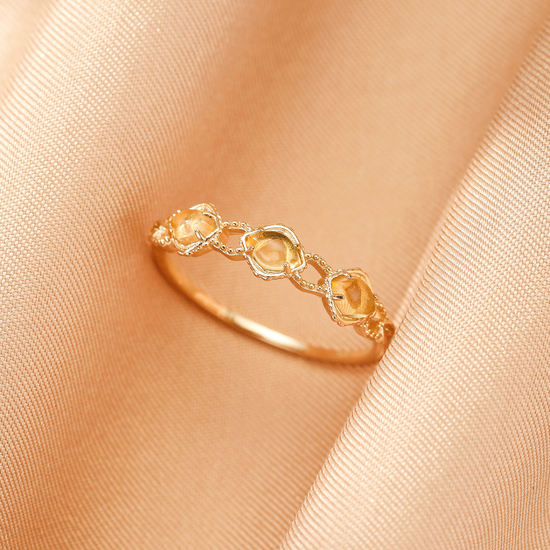 Bague citrine ovale en argent 925 plaqué or 14K, reflétant la lumière dorée, symbole de joie et vitalité, présentée sur un fond élégant.