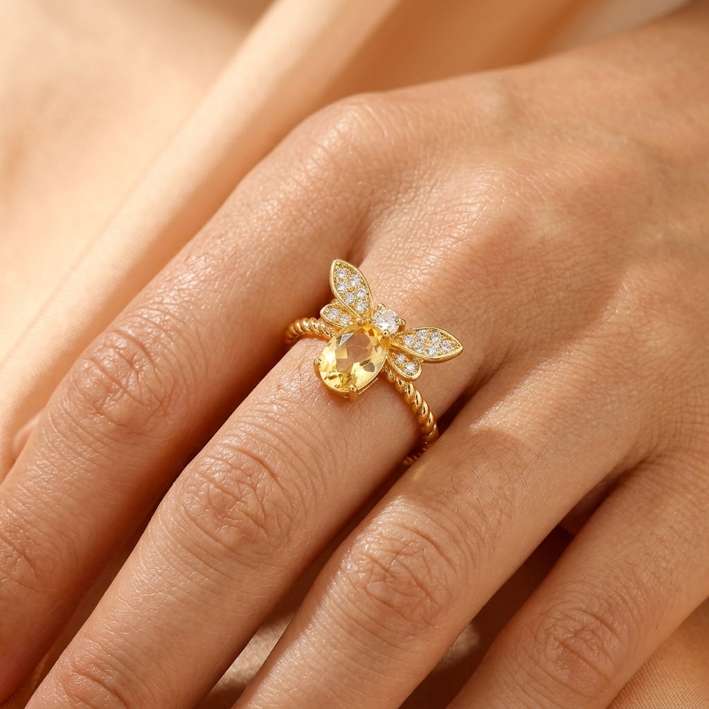 Bague Vol Lumineux avec pierre centrale citrine ovale et ailes en zircon sur argent plaqué or 14K portée au doigt