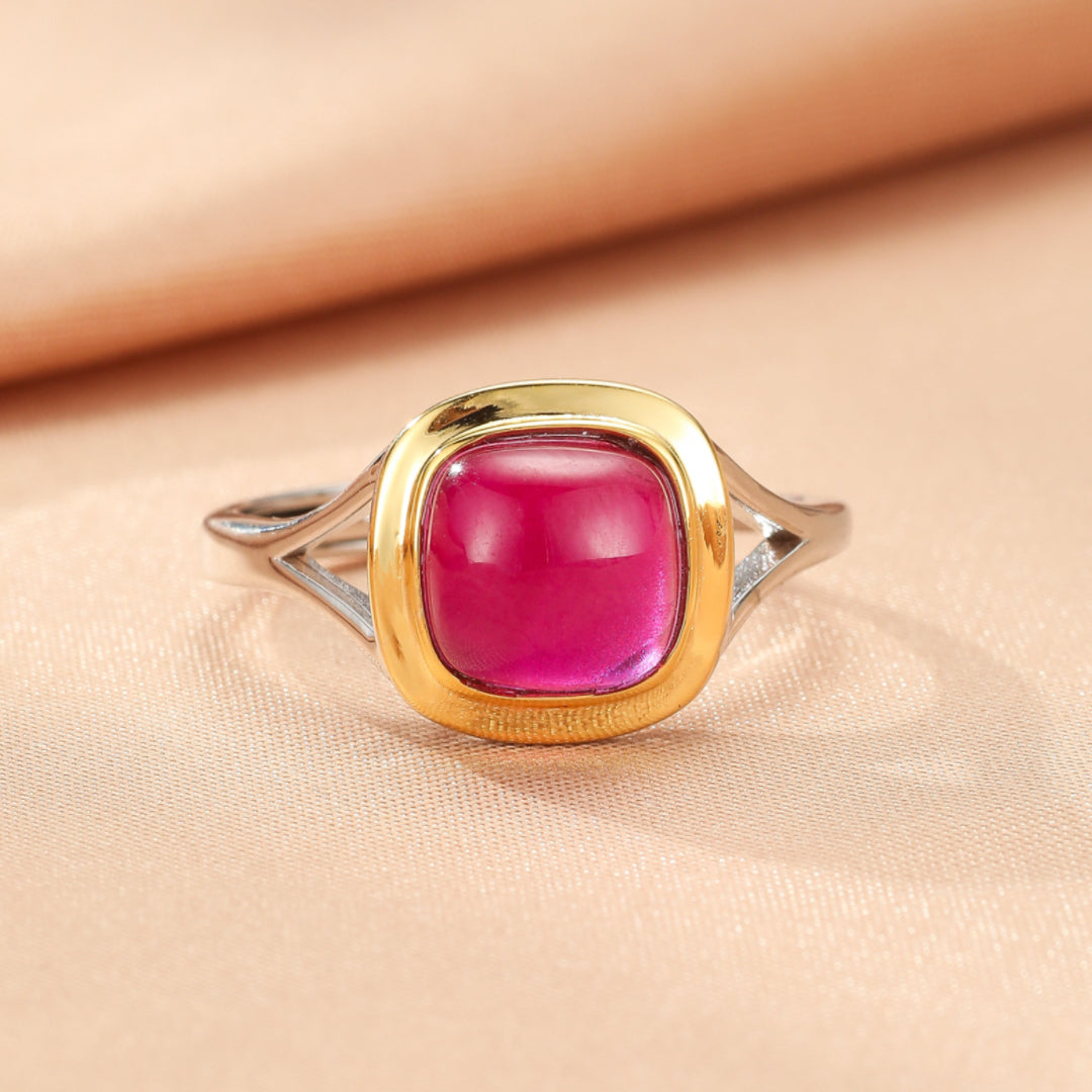 Bague contemporaine en argent avec une pierre de cornaline rose vif carrée, sertie dans un entourage doré.