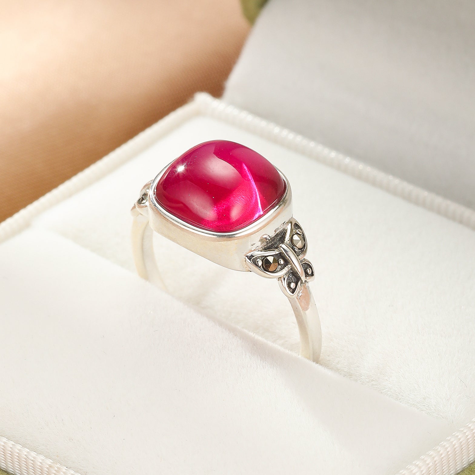 Bague en argent avec une cornaline rouge vif taillée en cabochon et des détails de papillon sur l'anneau.