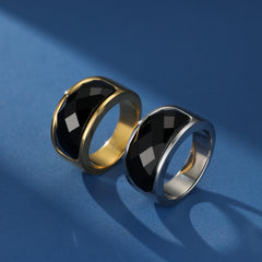 Bague pour homme en argent et or, sertie d'obsidienne noire facettée, sur fond bleu.