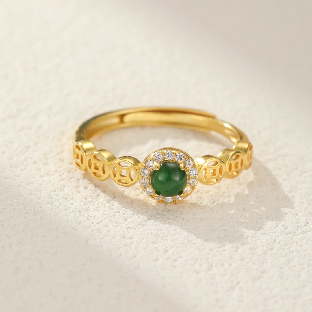 Bague ajustable en argent plaqué or avec une pierre de jade verte ronde entourée de zirconiums blancs et un motif de pièces de monnaie chinoises ajourées sur l'anneau.