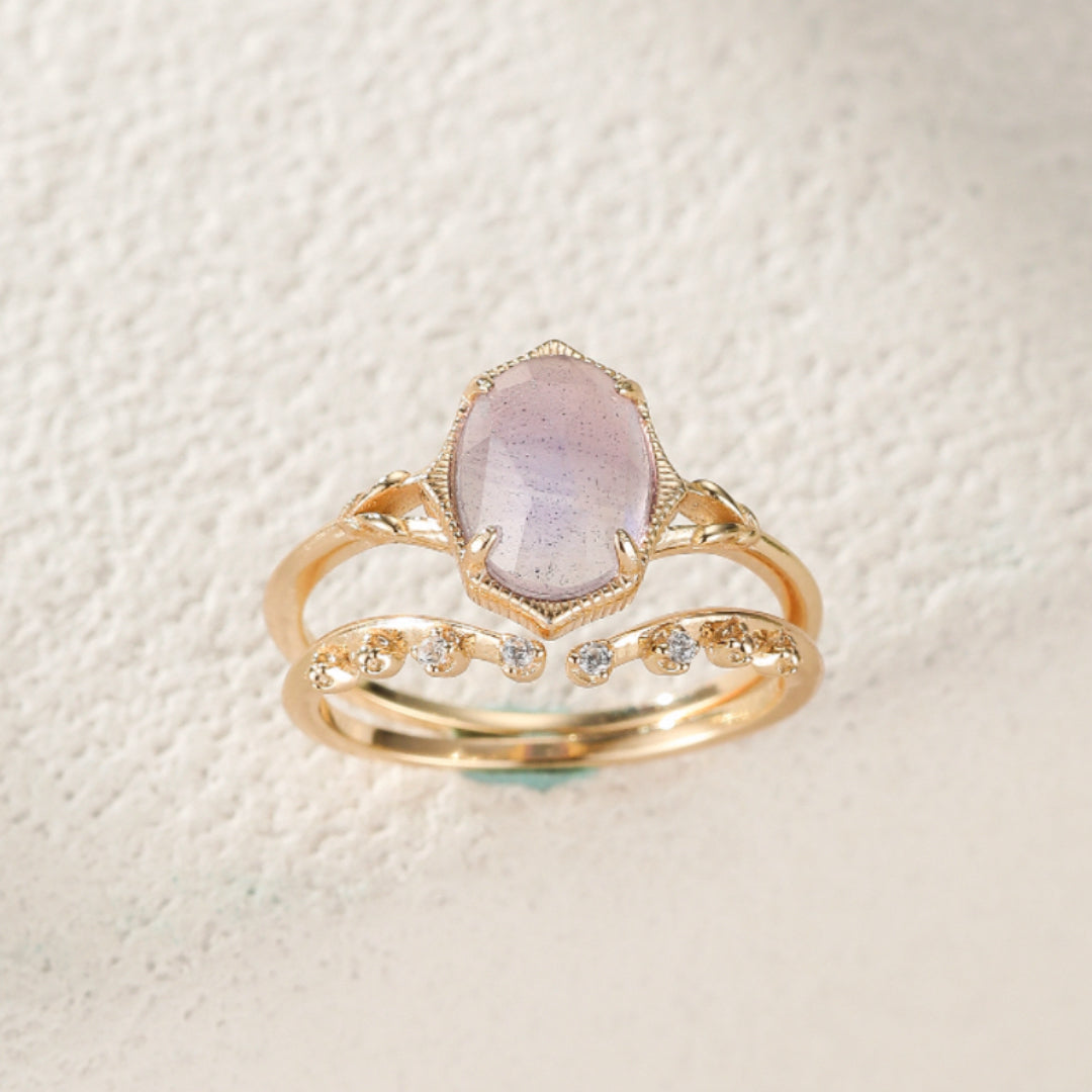 Bague empilable en argent plaqué or avec une labradorite ovale rose pâle et une alliance ornée de petites pierres scintillantes.