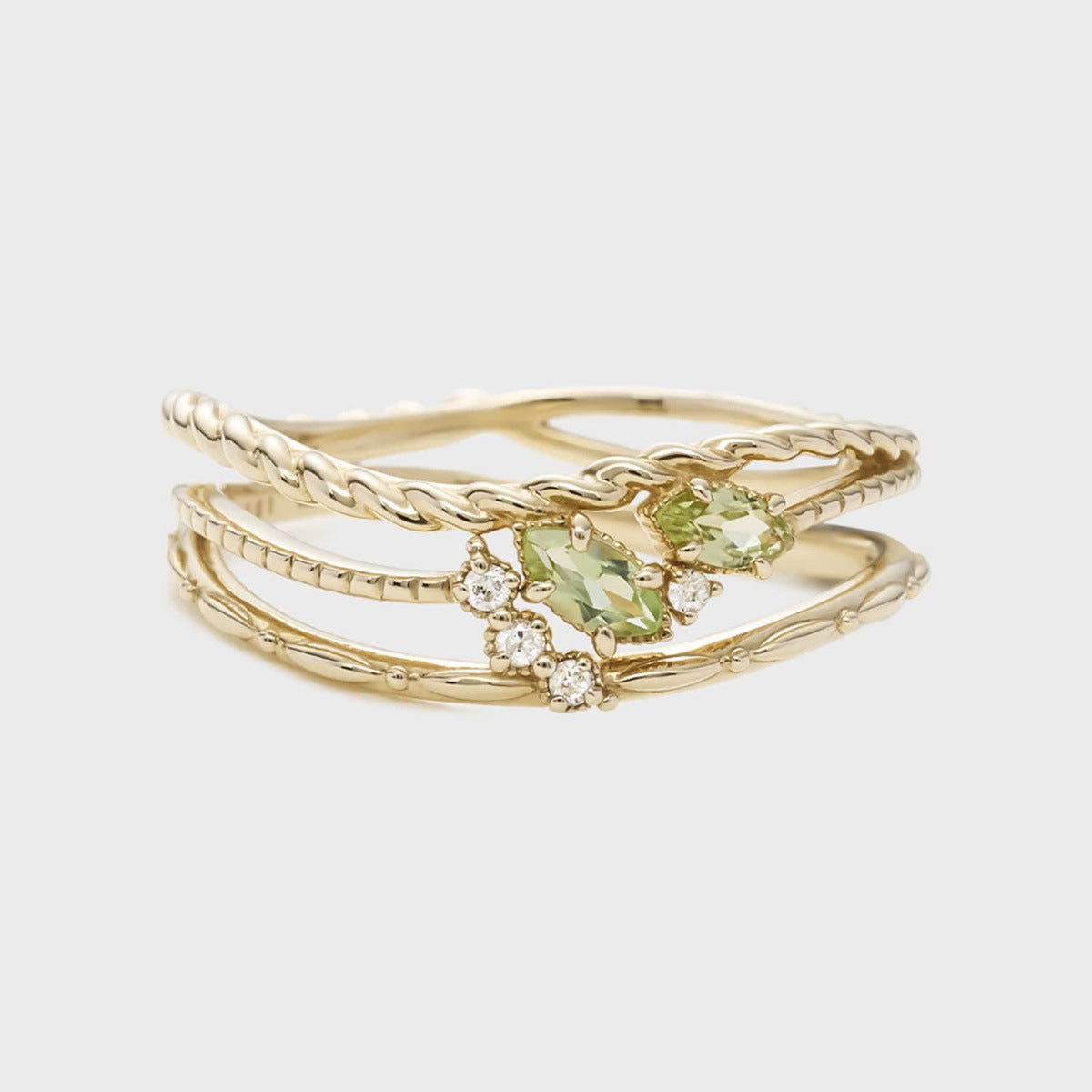 Bague superposition en argent plaqué or avec deux pierres d'œillets vertes et des diamants blancs, mise au point rapprochée.
